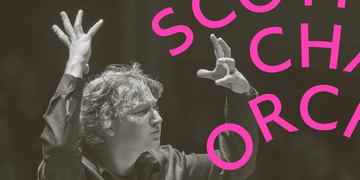 Maxim Emelyanychev raises his hand as he conducts